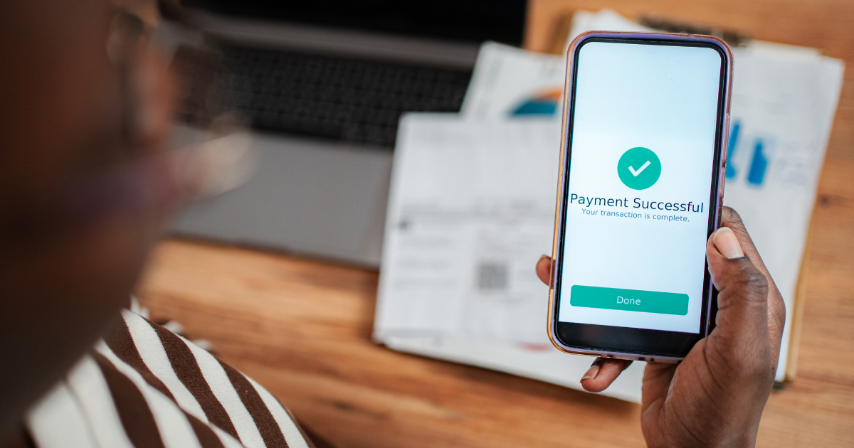 Person viewing a successful payment confirmation on a smartphone, symbolizing secure business payments and fraud prevention.