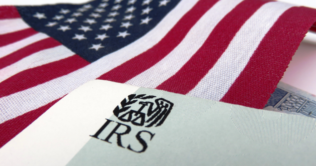 IRS tax document beneath an American flag, representing federal tax payments, IRS updates, and electronic payment requirements.