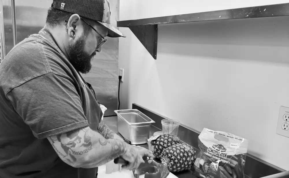 Chef Steve Ramirez preparing fresh ingredients in the kitchen, showcasing his farm-to-table approach and culinary craft.