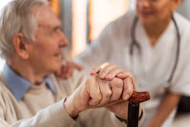 Elderly patient with walking cane being supported by caring medical professional