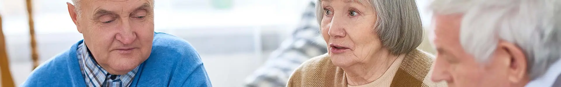 Elderly people sitting together, looking serious and contemplative