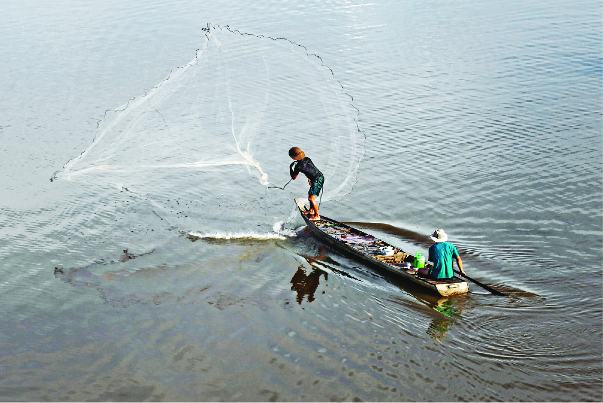 Indigenous fishermen on a wooden boat in a high-risk region