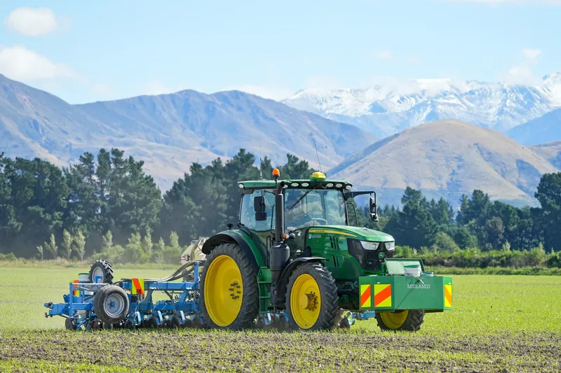 Tractor sowing seed with Southern Alps in the background