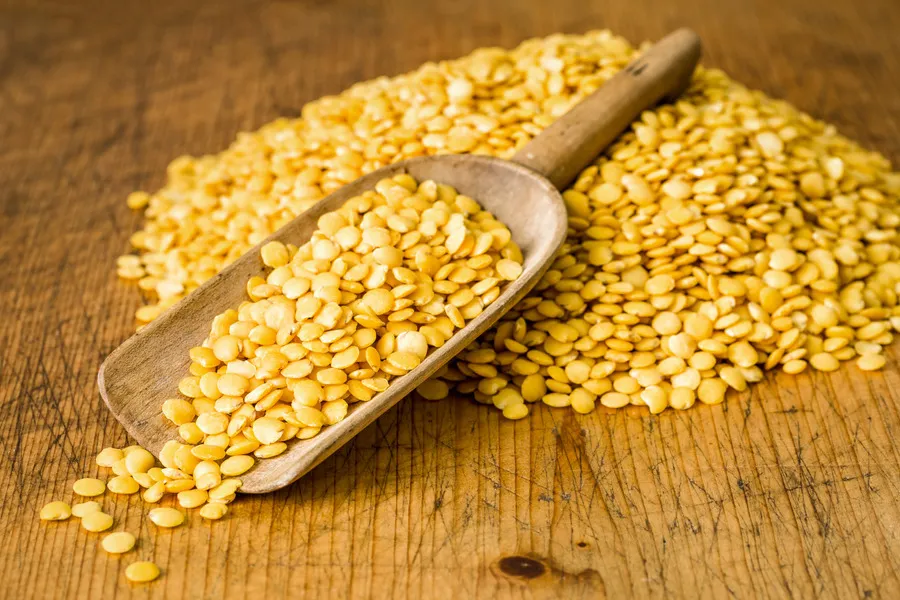 Yellow Lentils on Wooden Scoop