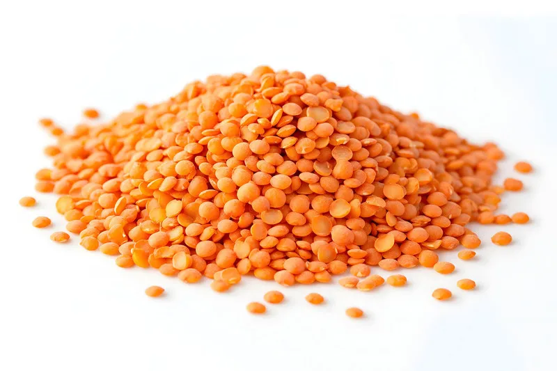 Pile of red lentils on white background