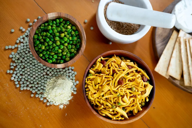 Wasabi peas, bhuja mix and blue peas on wooden table