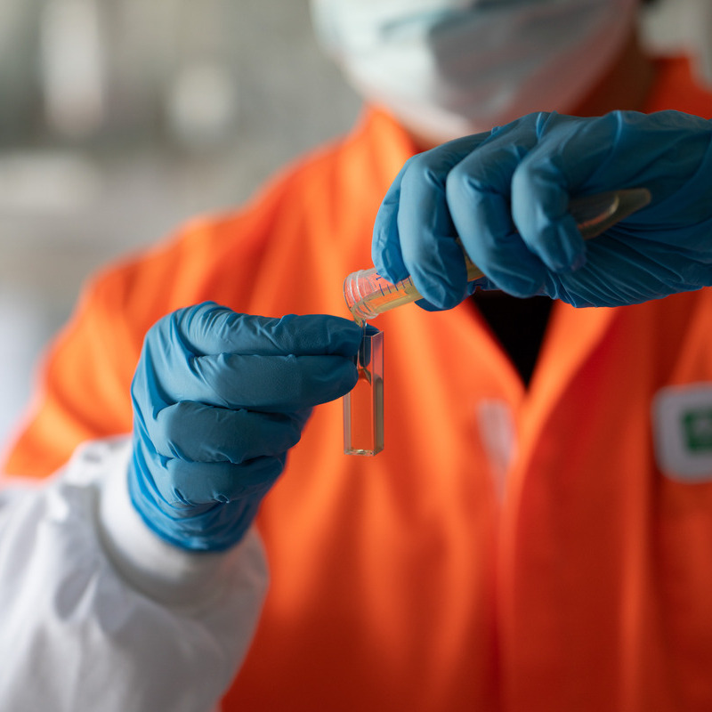 Technician pouring honey into a test tube
