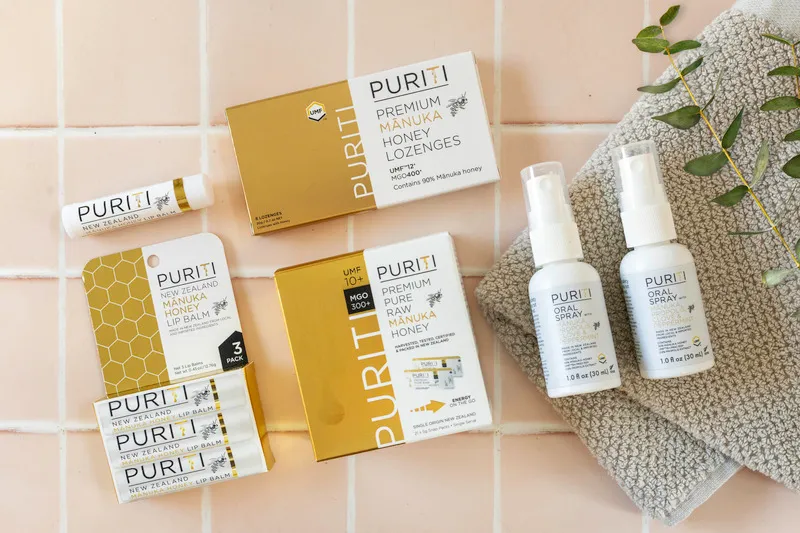 Puriti Lip balms, lozenges, snap packs and oral spray on pink tiles