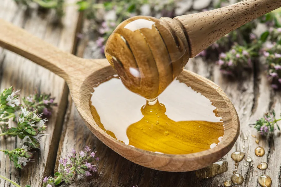 Thyme honey in a wooden spoon