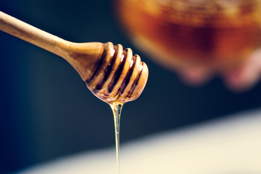 Honey dipper dripping honey
