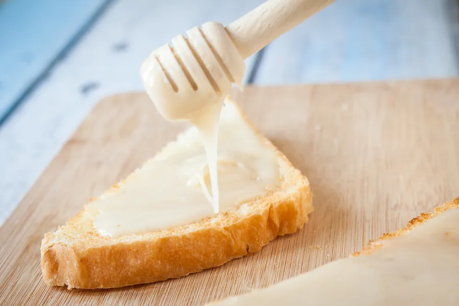 Rata honey on toast with wooden dipper