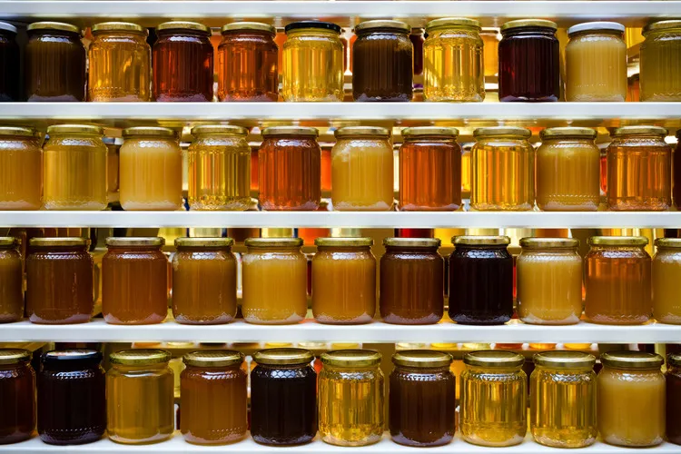 Shelf with wide range of honey in jars