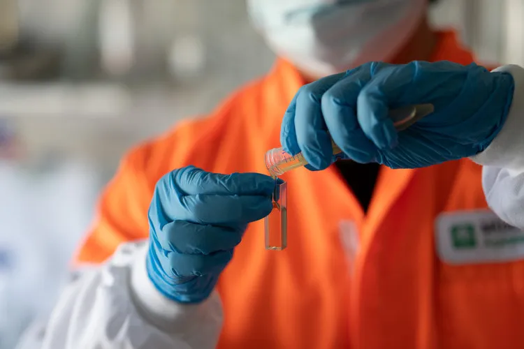 Technician pouring honey from a test tube for testing
