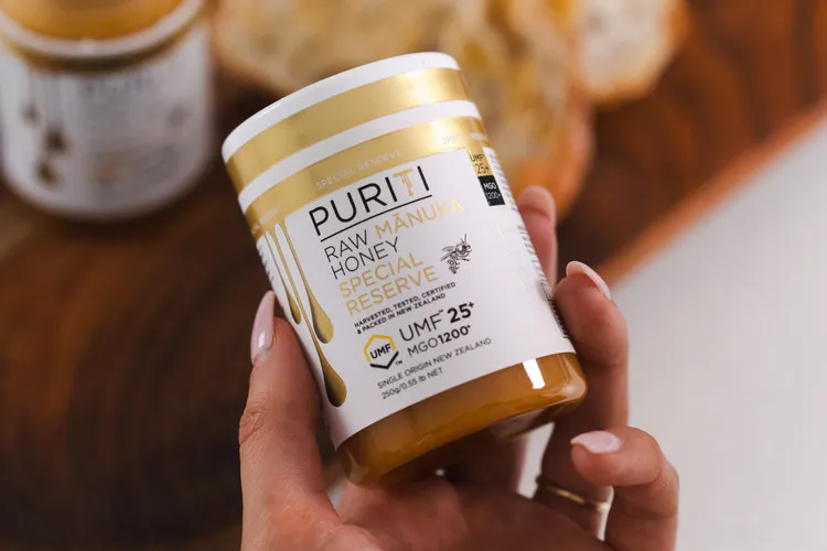 Women holding a jar of Puriti Manuka honey UMF 25+