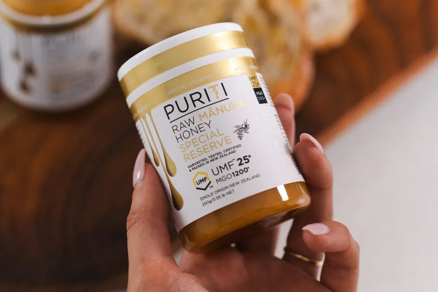 Women holding a jar of Puriti Manuka honey UMF 25+