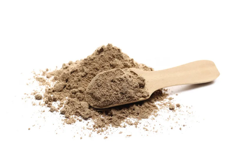 Flaxseed fibre in wooden scoop on white background