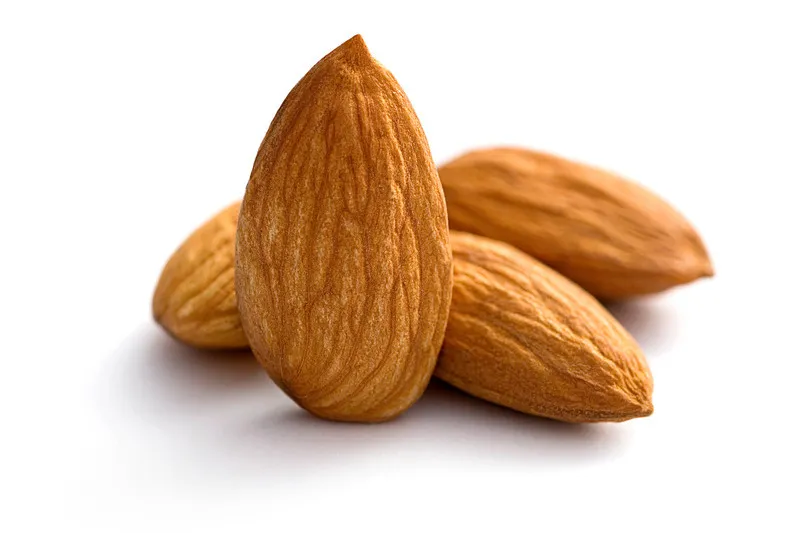 Four almonds in a pile on a white background