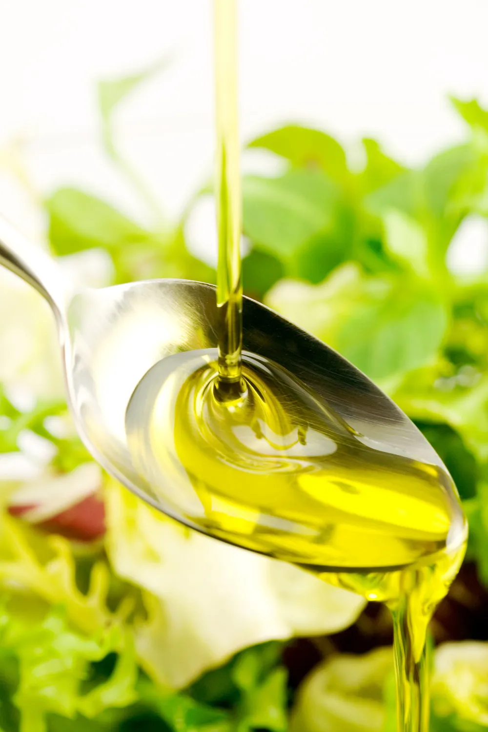 Almond oil dripping on spoon