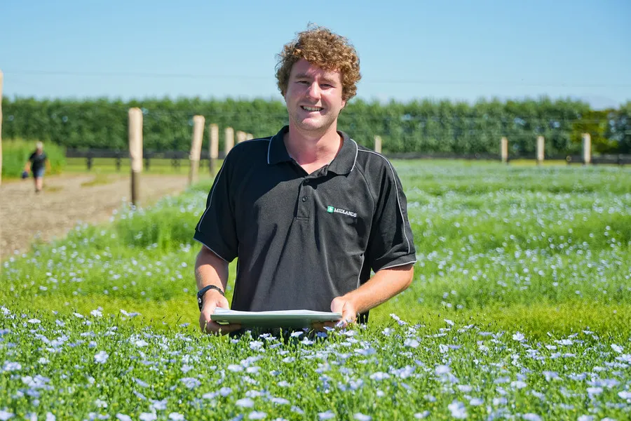 Man with clipboard inspecting a Flaxseed Crop trial