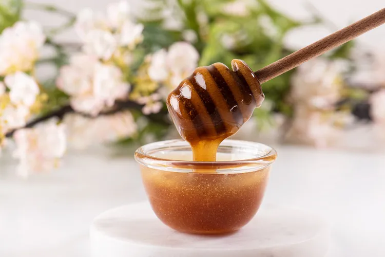 Kamahi Honey in small bowl with wooden honey dipper