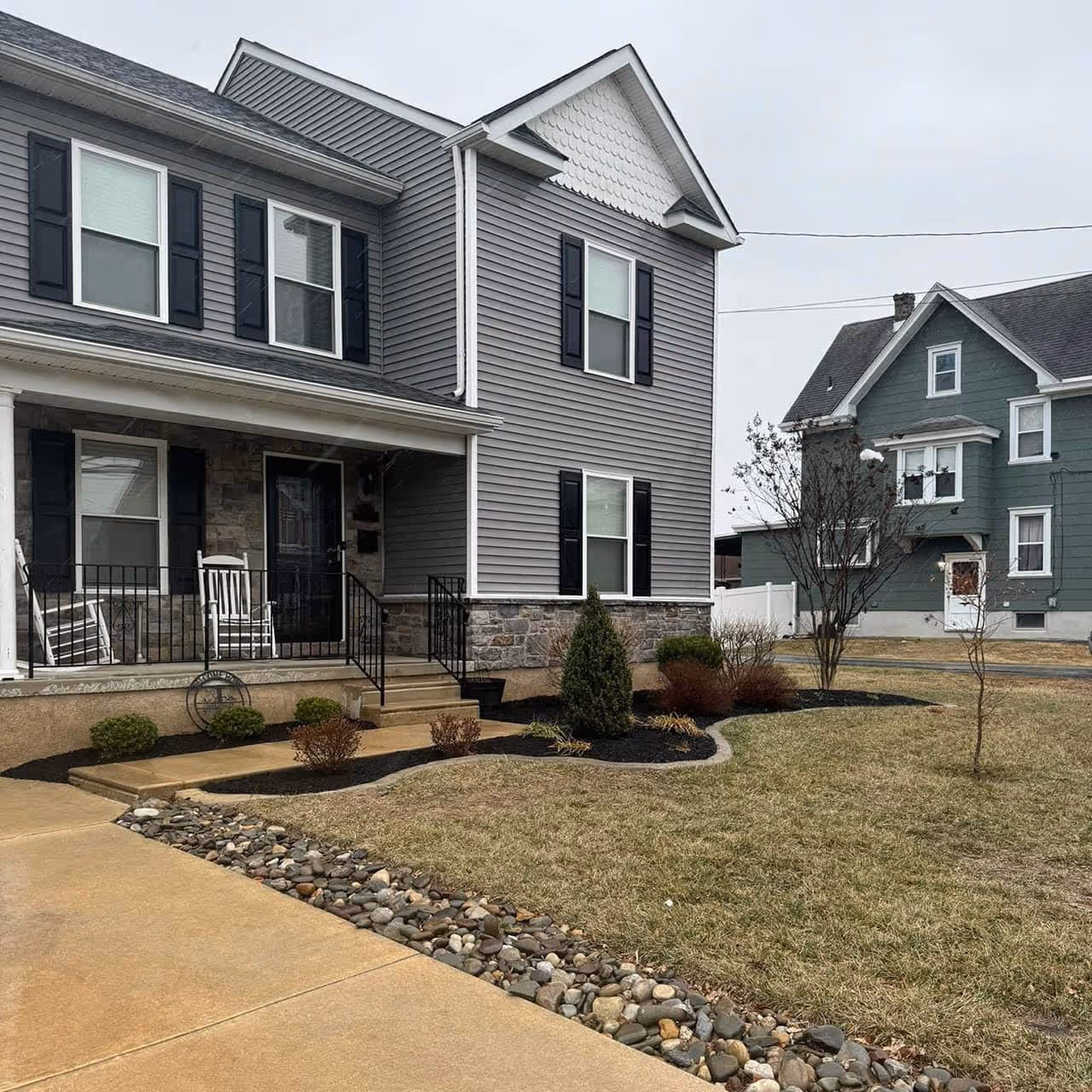 Trimmed yard with landscaped mulch and flower bed in front of home  by Morrisroe Landscaping for great landscaping in Delaware County.