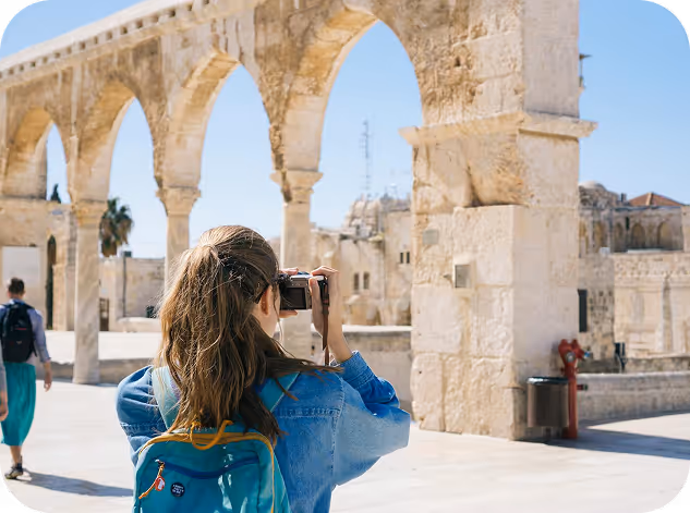 image of a woman clicking photographs of ancient sculpture 