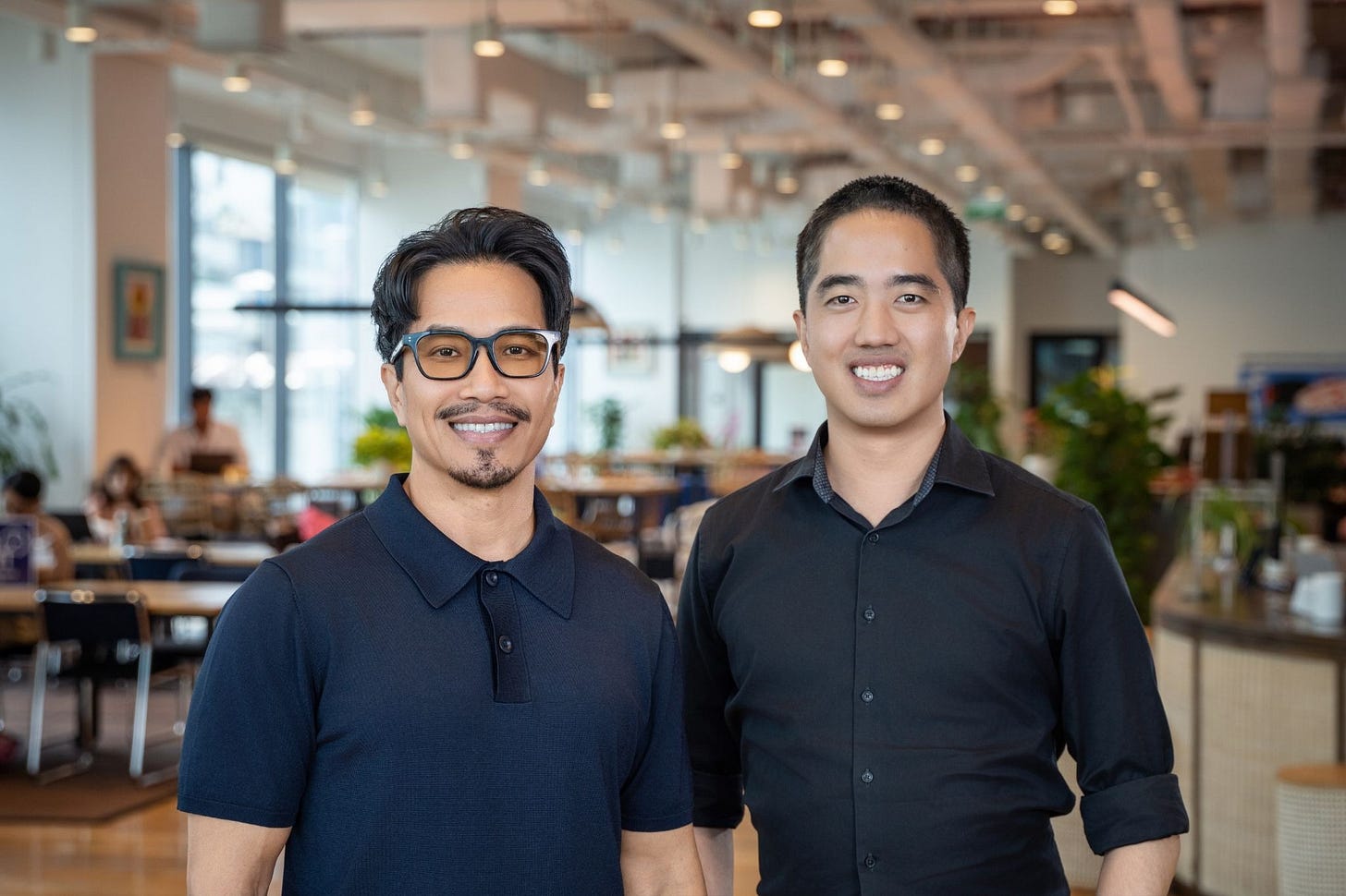 Eddie Thai and Binh Tran in an office building.