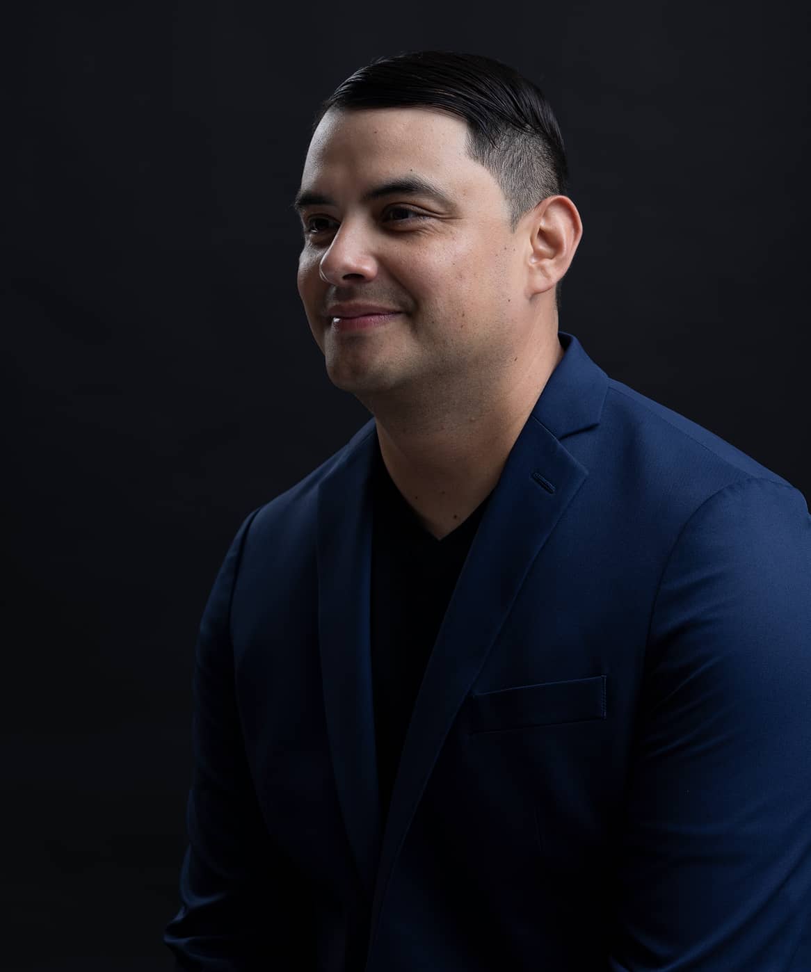 Man wearing a formal suit, standing confidently with a professional appearance