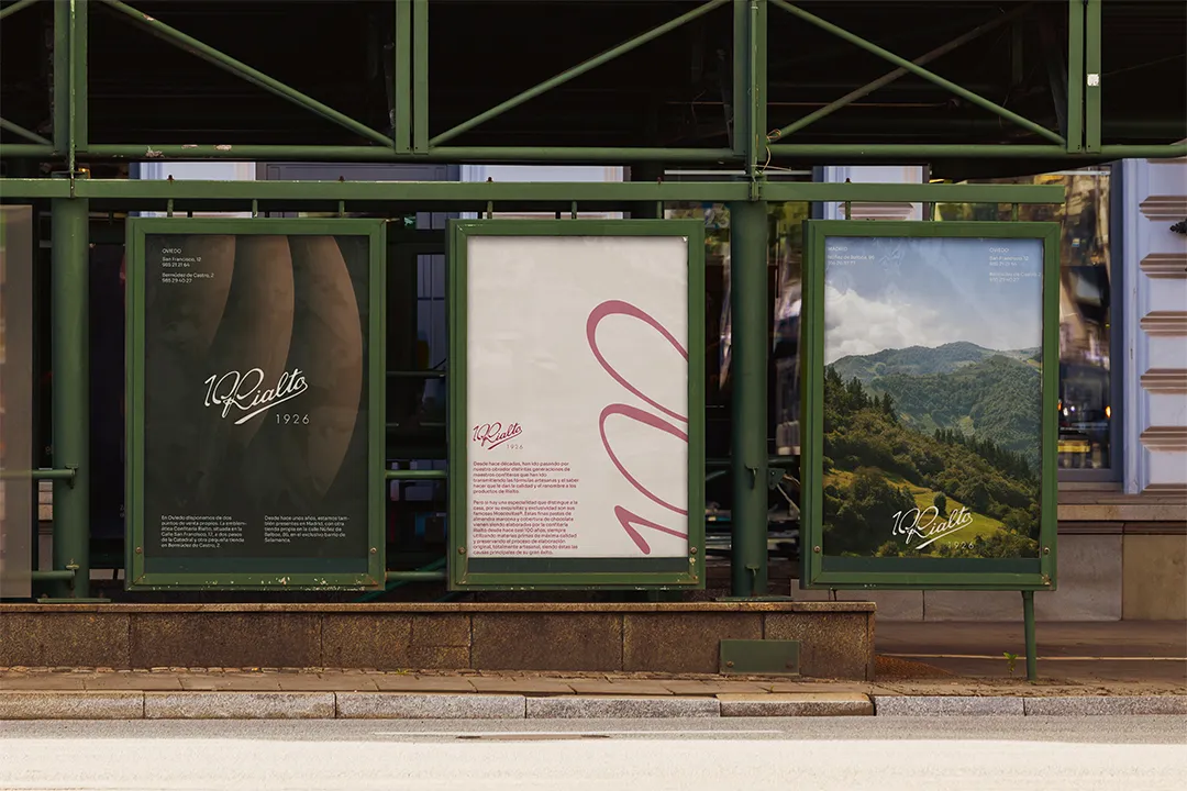 Tres carteles expuestos en una parada de autobús con el texto '10 Rialto 1926' y un fondo de paisaje montañoso, texto explicativo y detalles de ubicación.