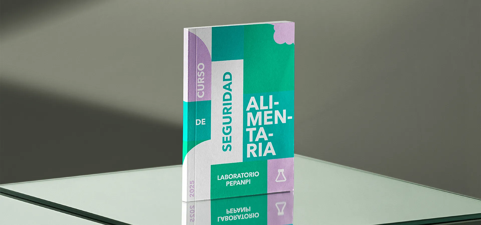 Libro de curso titulado Seguridad Alimentaria del Laboratorio PEPANPI sobre superficie reflectante.