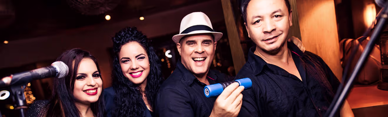 A lively musical group smiles together during a performance.