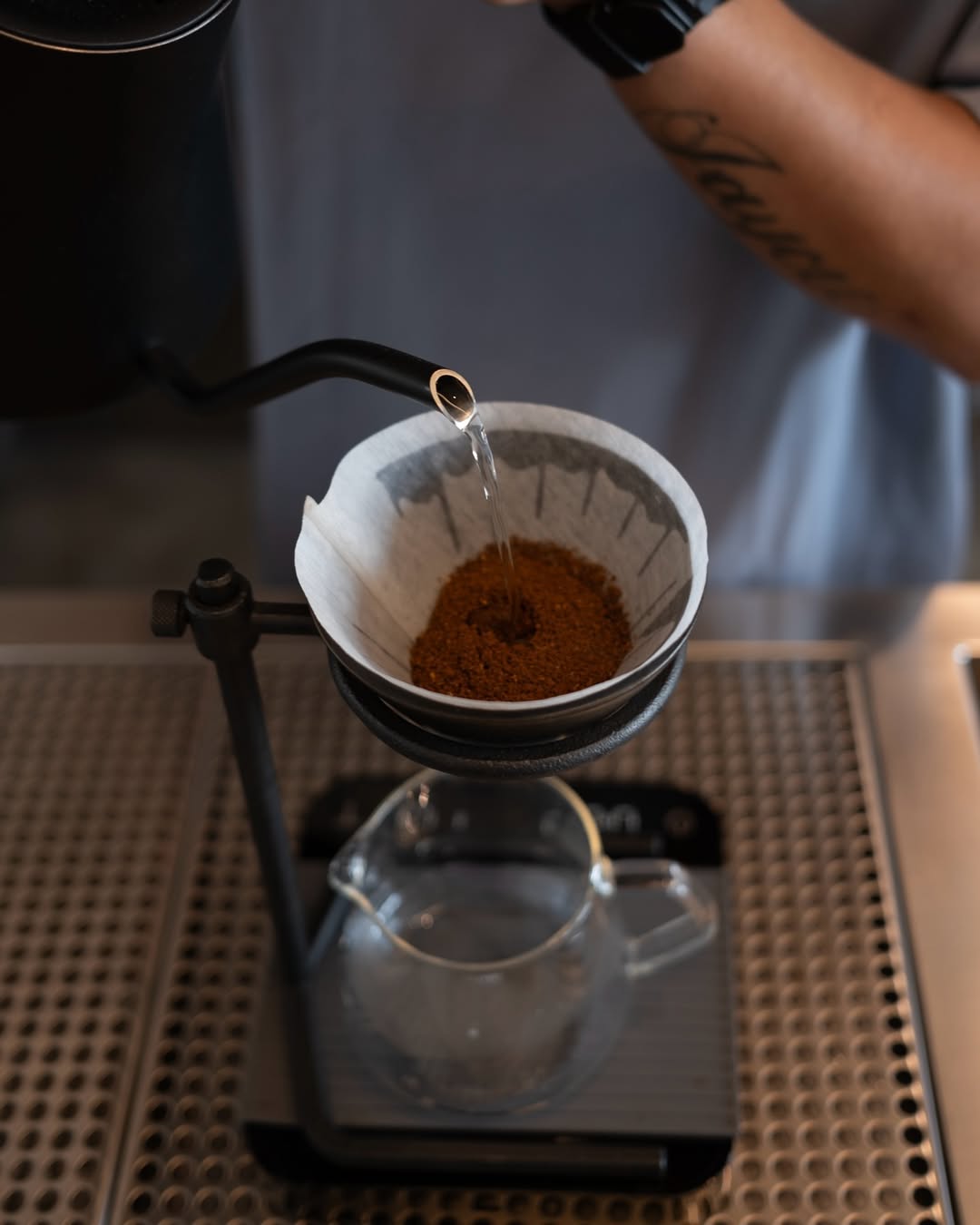 Hot water is poured over ground coffee in a paper filter for a pour-over brew.