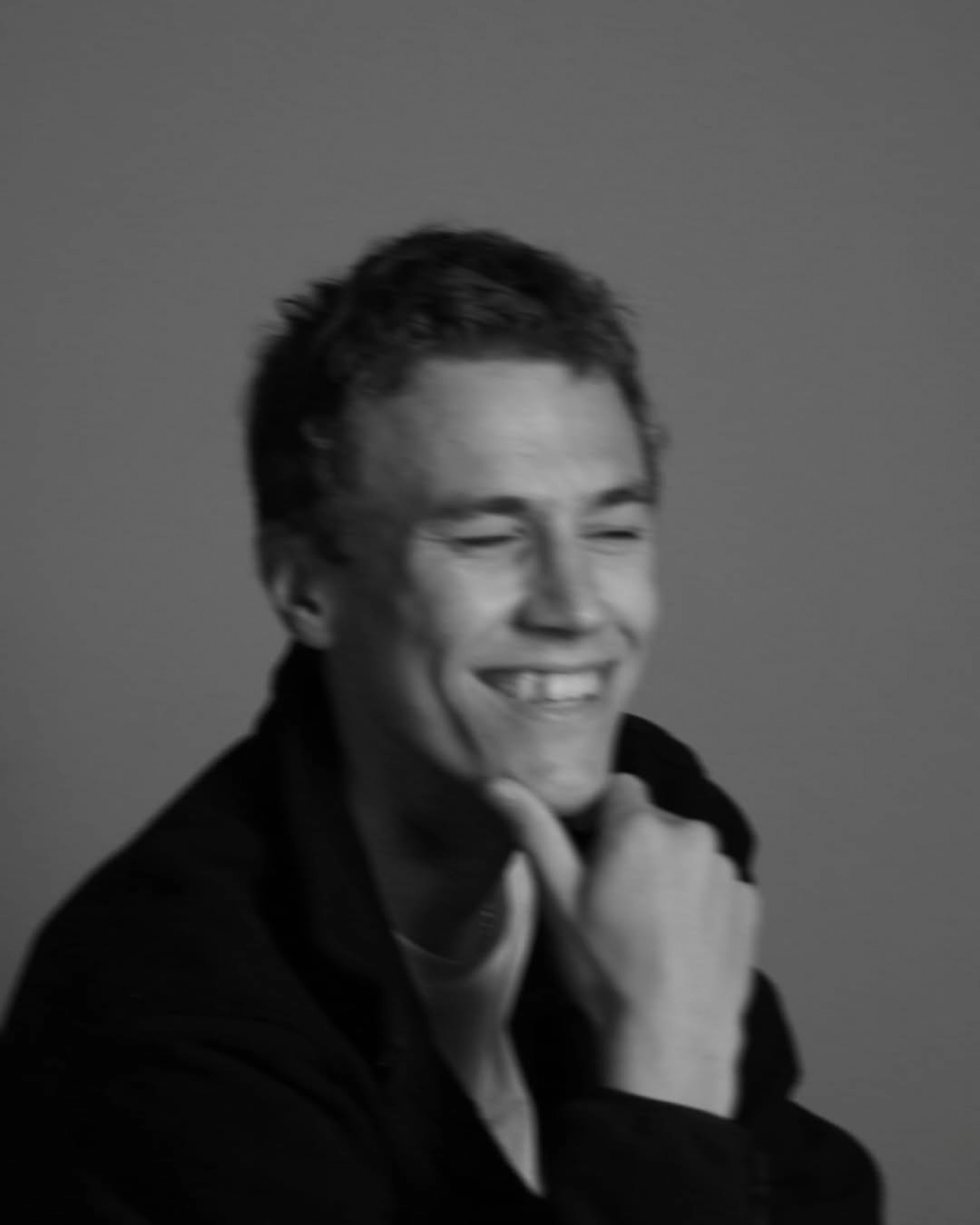 Relaxed photo of Roman Burachevsky standing against a wall.