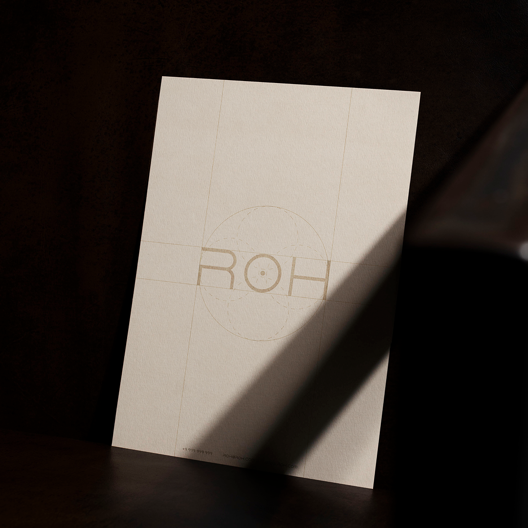 Beige sheet of paper with faint geometric logo and 'ROH' logo partially shaded by diagonal shadow.
