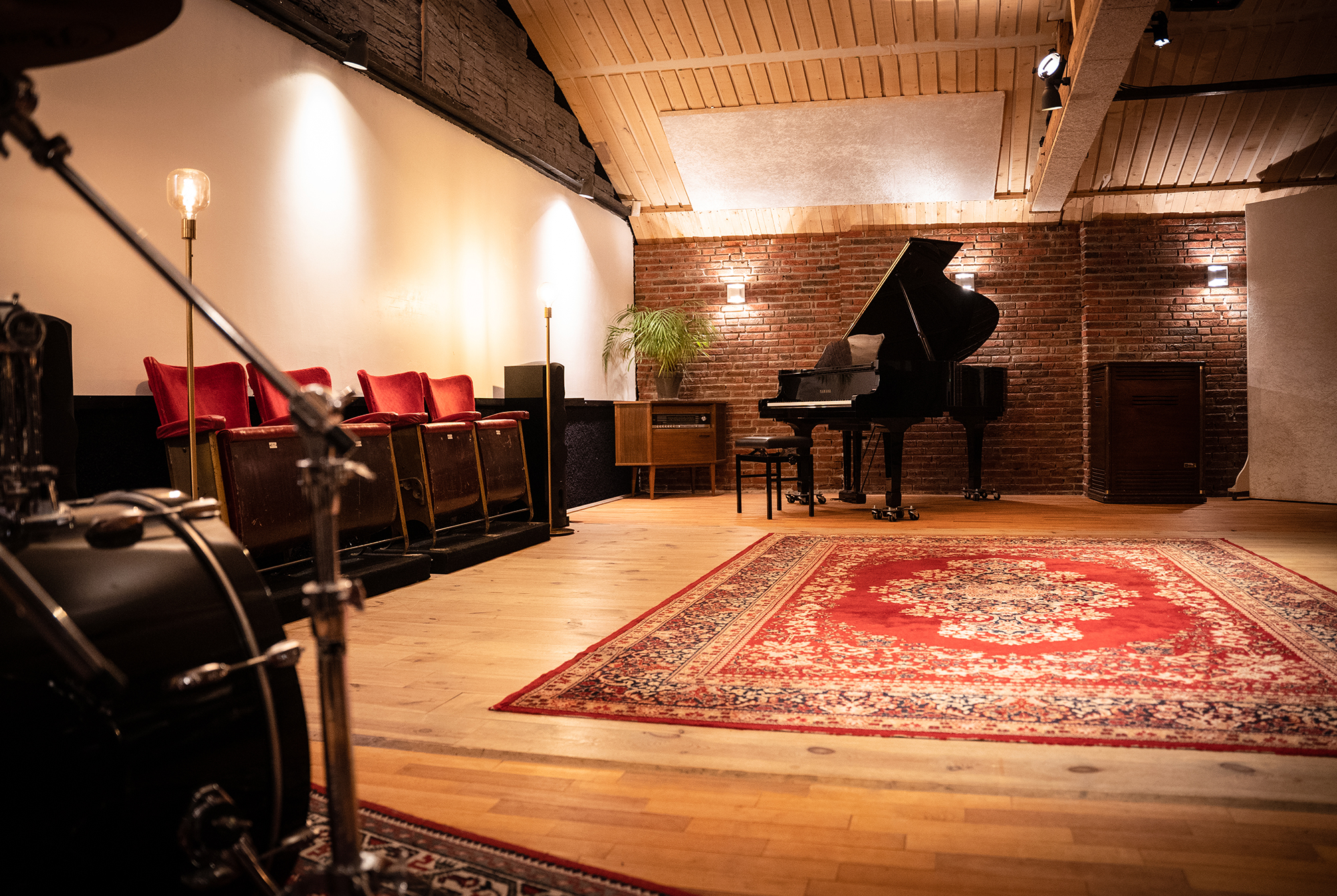 De live-room van Studio A60 met vleugel, houten vloer en rode bioscoopstoelen