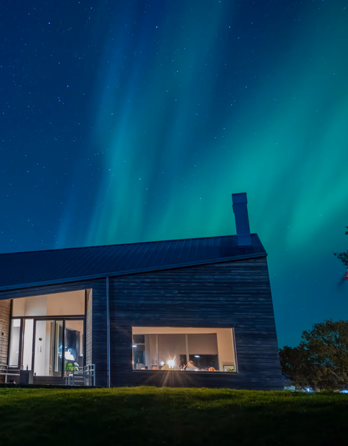 Nordlys danser over den arkitekttegnede lodgen på Skagenhaugen – magisk arktisk natt i Vesterålen.