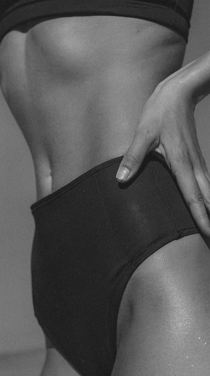 close up of the body of a woman with her hands on her waist 