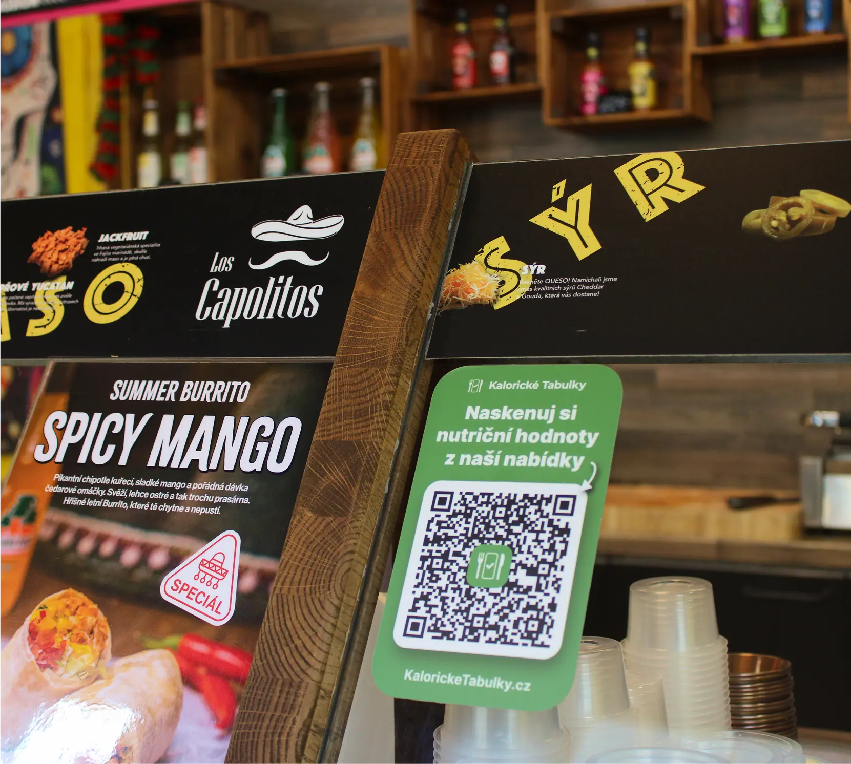 Ukázka prodejny a nalepeného QR kódu pro použití aplikace Kalorických Tabulek