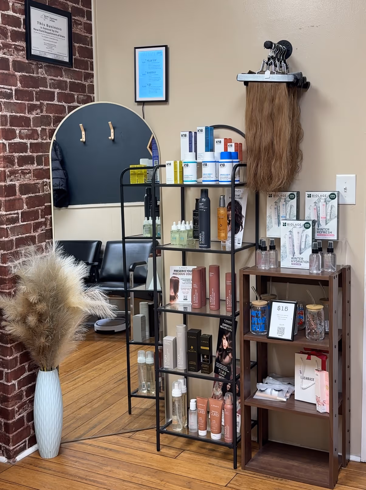 A hair salon with a brick wall and shelving.