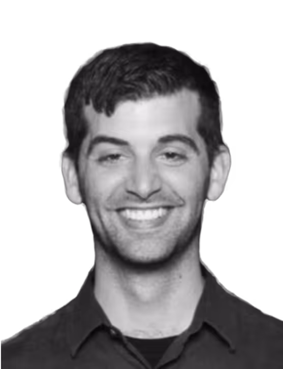 Smiling man with short dark hair wearing a dark collared shirt.