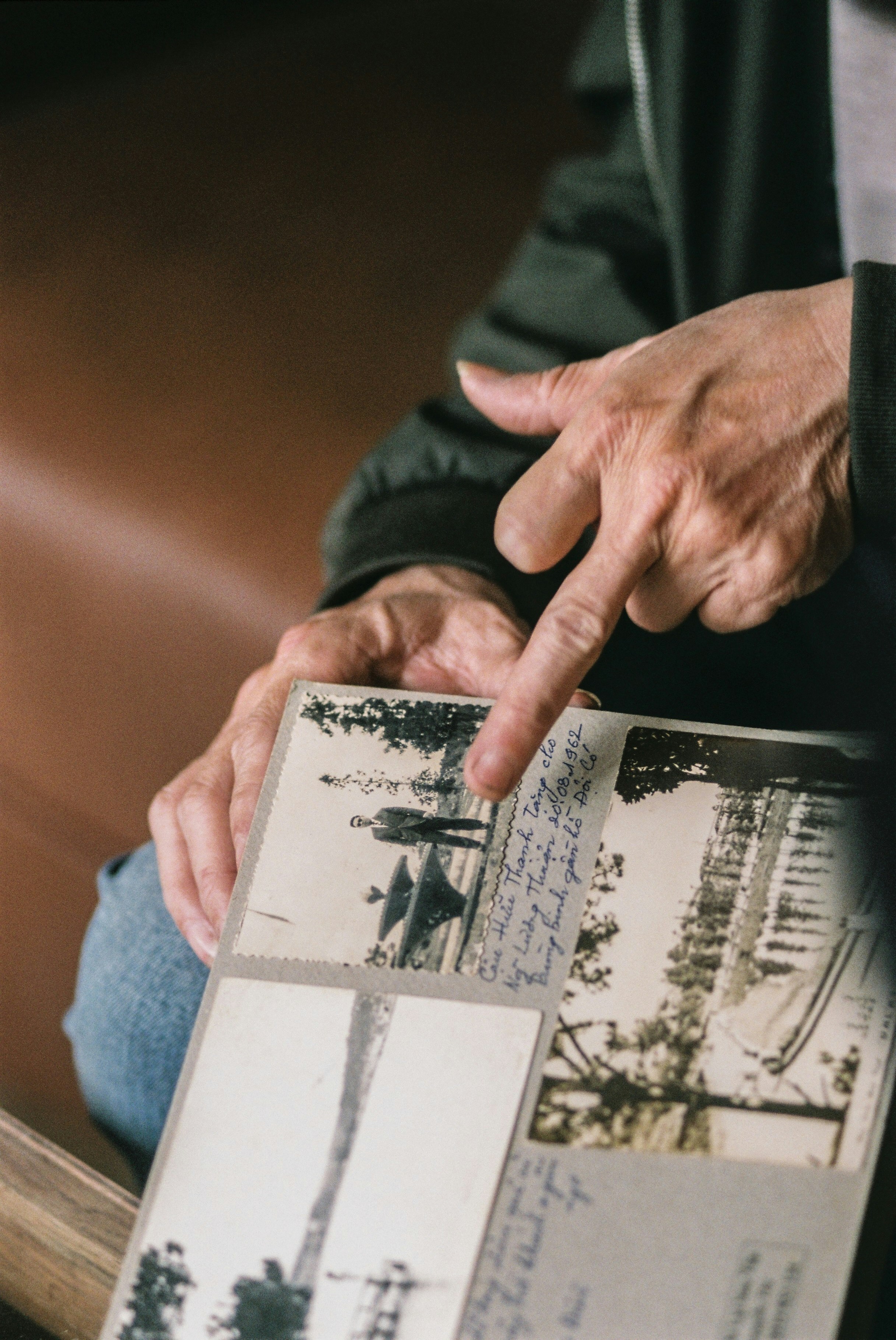 An older person's hand holding an old photograph