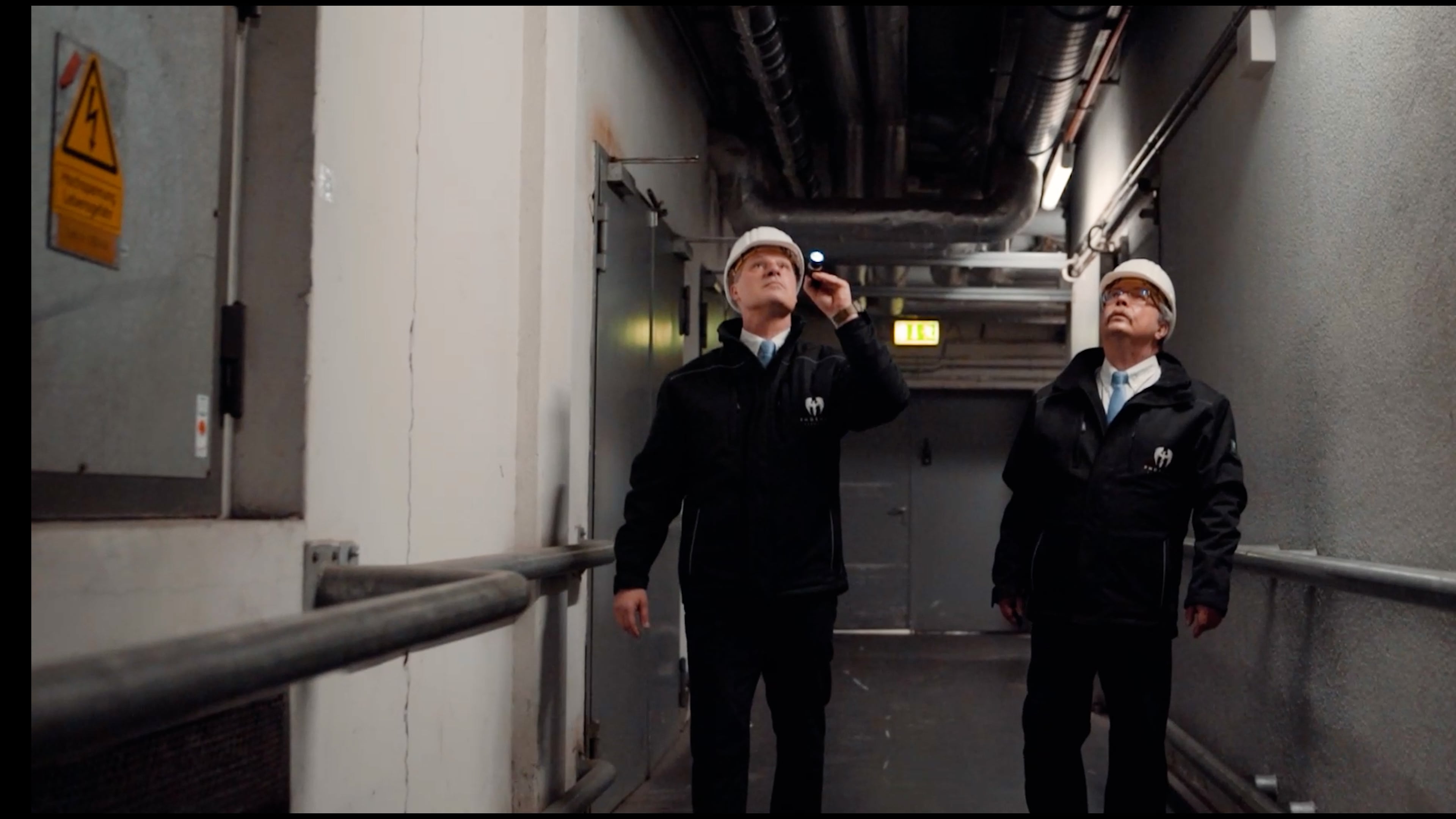 Sicherheitsmitarbeiter Phoenix Security, Rundgang Objektschutz und Werkschutz mit Sicherheitshelm und Dienstkleidung.