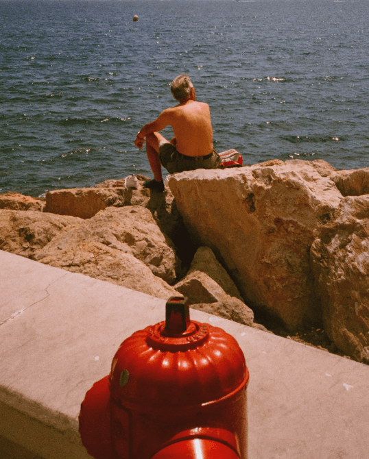 An analog photography of a man looking at the sea took in Cannes, France