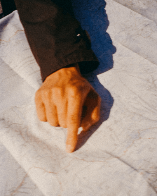 An analog photography of a hand showing a place on a paper map took in Reykjavik, Iceland