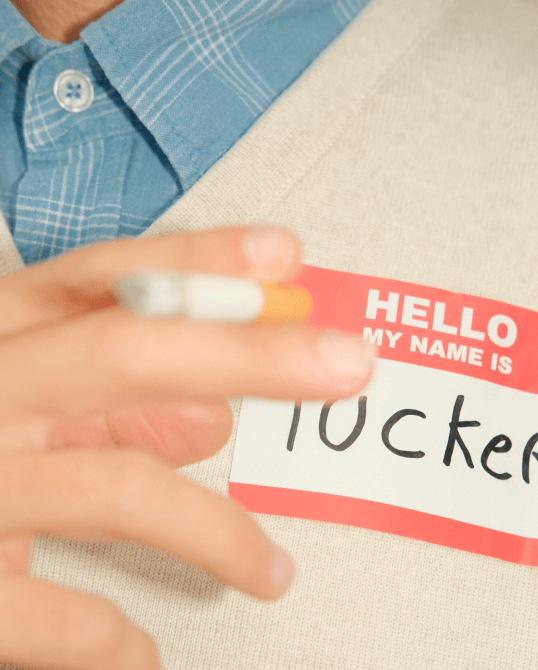 A digital photography of a man smoking a cigarette with a sticker hello my name is