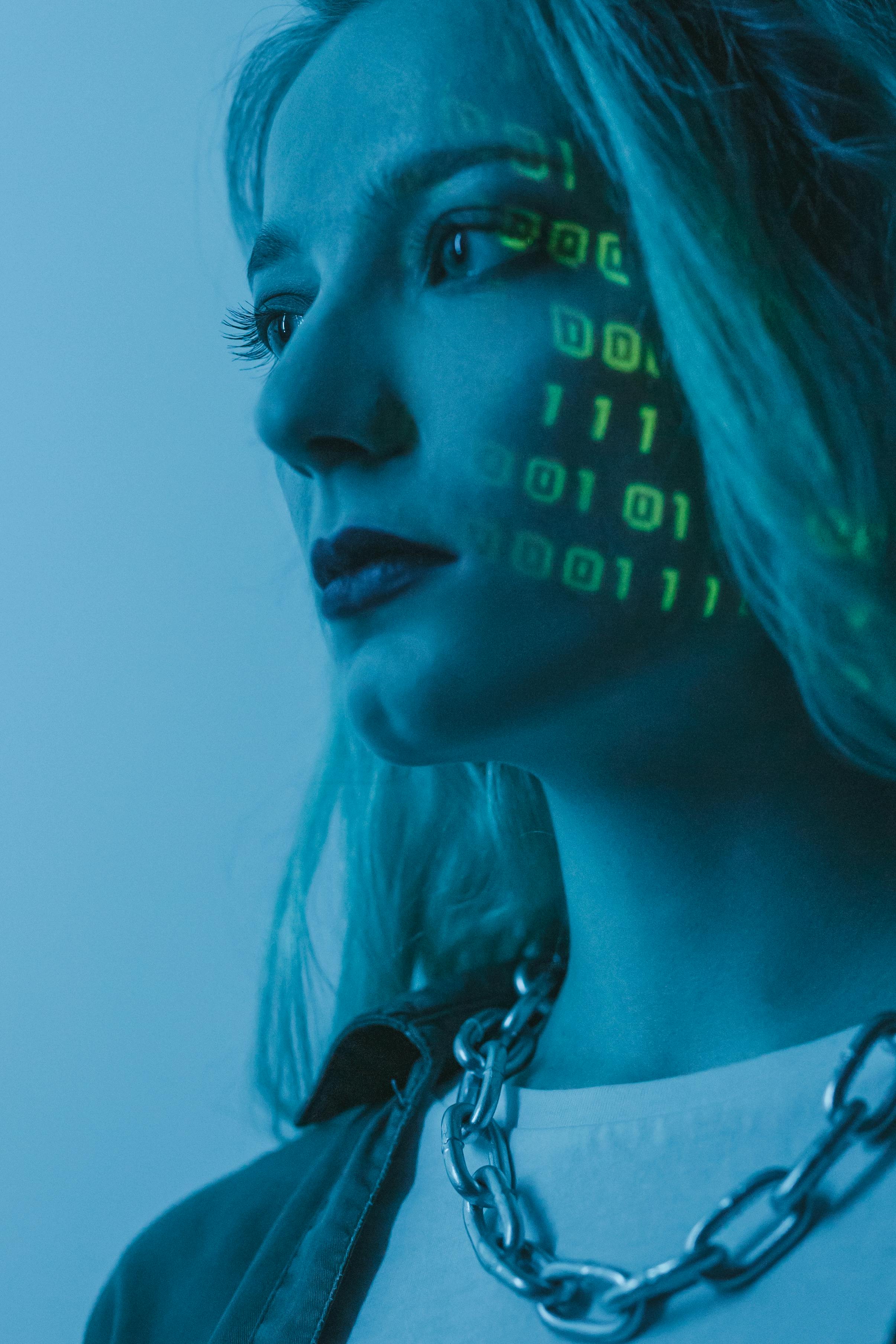 Portrait d’une femme éclairée par du code binaire, représentant la technologie et la transformation digitale.