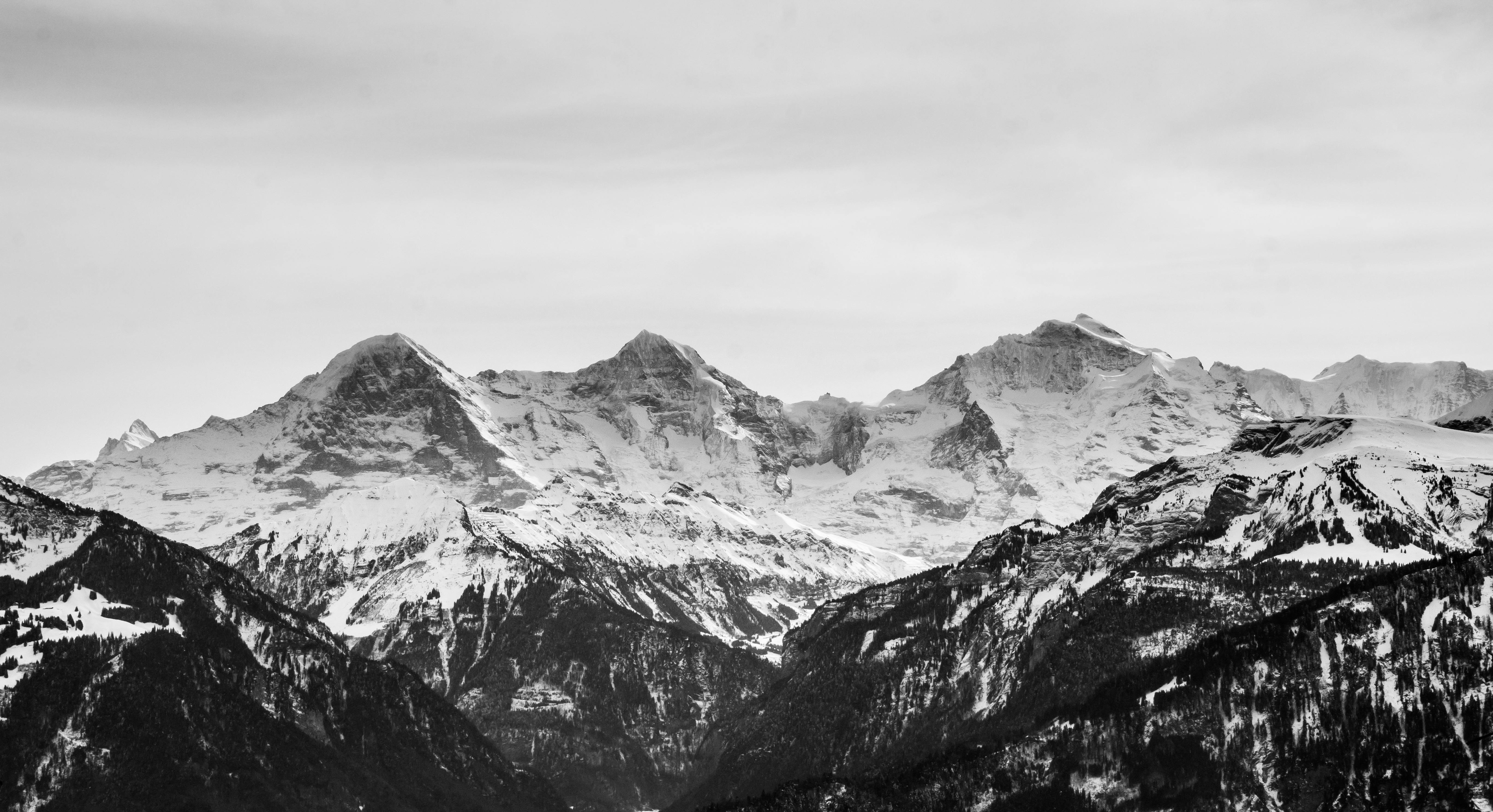 Chaîne de montagnes enneigées en noir et blanc.