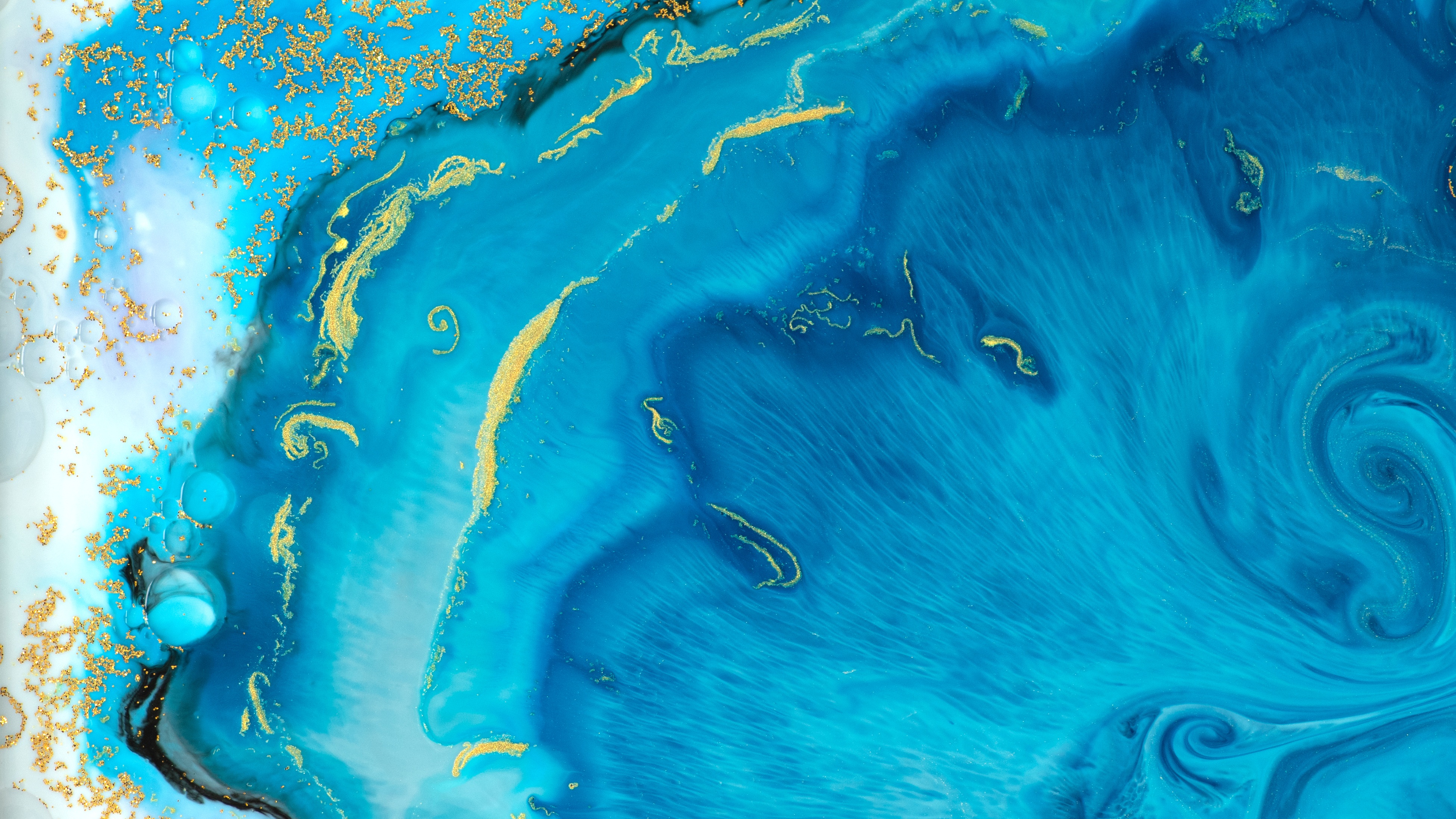 A blue and gold fluid painting with gold flecks.