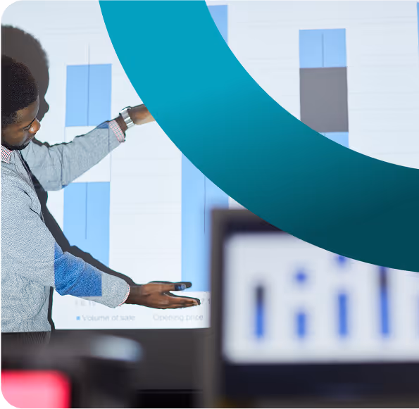 Presentazione con proiettore di un grafico a barre, spiegato da un uomo.