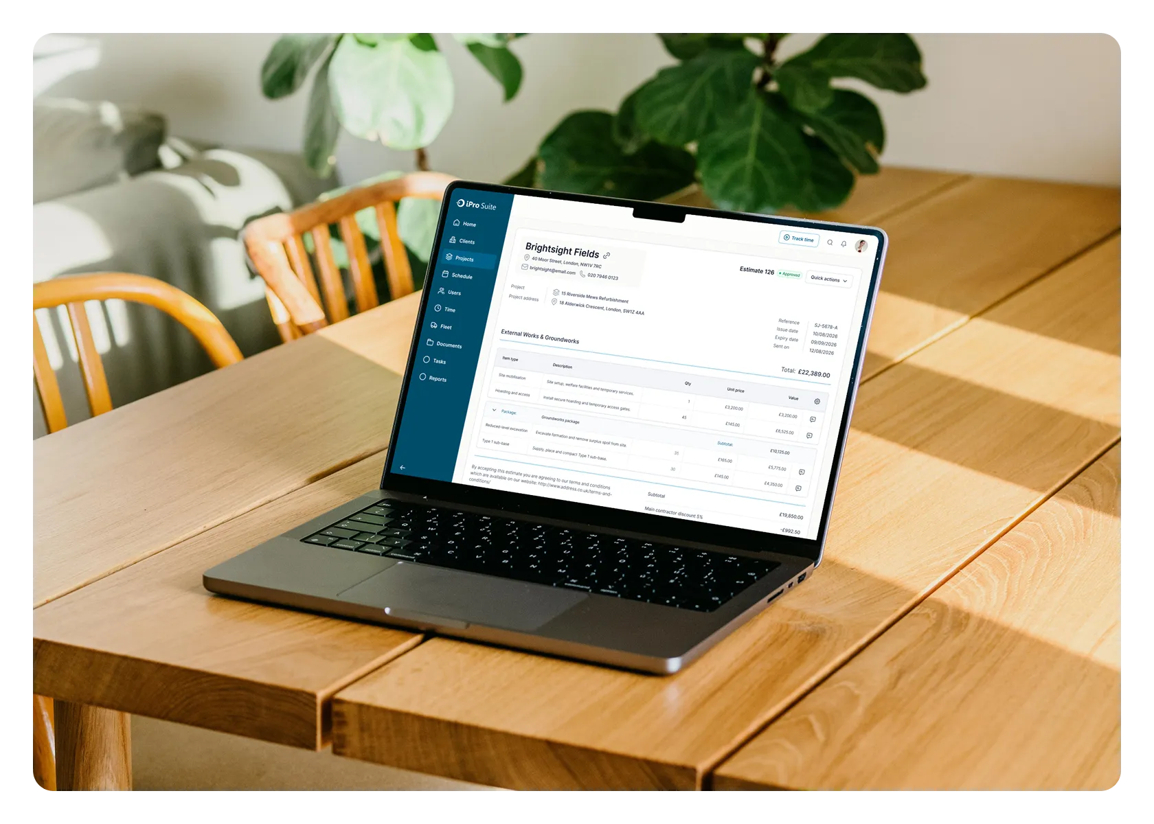A laptop displaying an iPro Suite estimate on a table.